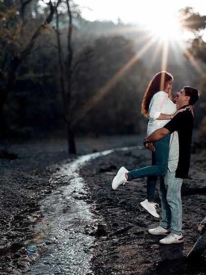 A playful lift in a forest clearing, with the sun creating a starburst effect. This shot is full of energy, romance, and beautiful natural light.