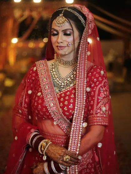 A classic red bridal look, featuring a layered polki necklace that adds depth and grandeur to the ensemble.