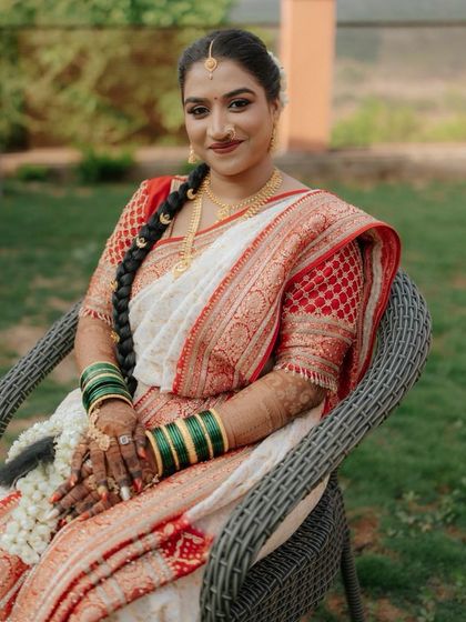 A portrait of our beautiful South Indian bride in her classic white and red saree. The look is completed with a traditional braided hairstyle and fresh flowers.