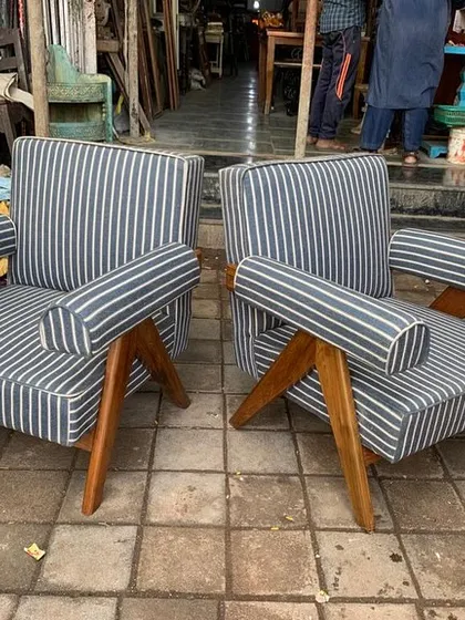 A pair of Pierre Jeanneret inspired V-leg armchairs with unique cylindrical armrests and striped upholstery.