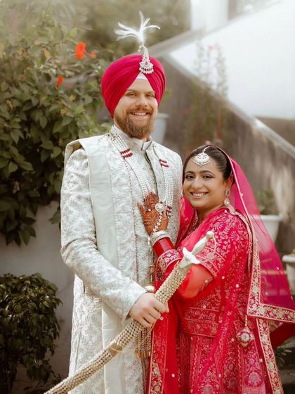 A joyful portrait of Paramneet and Samuel, their smiles radiating happiness. The groom holds a kirpan, honoring Sikh tradition.