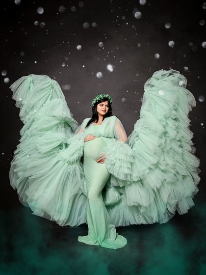 An angelic solo portrait featuring our mint green ruffled gown with the fabric tossed to create beautiful wings. The smoky effect at the bottom adds to the magical atmosphere.