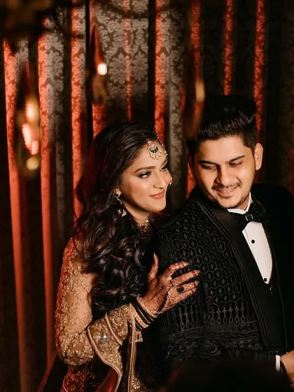 A candid and happy moment between the couple. The bride's hand on the groom's shoulder and their shared smile create a natural and heartwarming portrait.