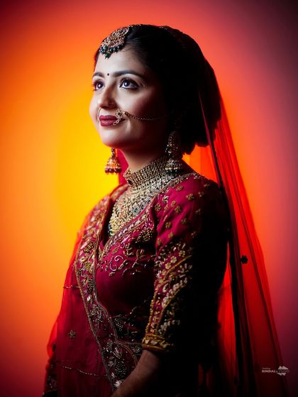 A hopeful and radiant bridal portrait. The bride looks up, her face illuminated by a warm, colorful light, creating a beautiful and optimistic image.
