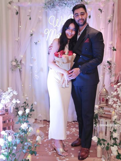 The happy couple posing for a photo after their engagement. Our setup, with its warm lighting and romantic elements, ensures every picture from the special day looks stunning.