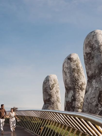 A joyful shot of a couple running hand-in-hand across the Golden Bridge in Vietnam. This image is full of energy and captures the excitement of their journey together.