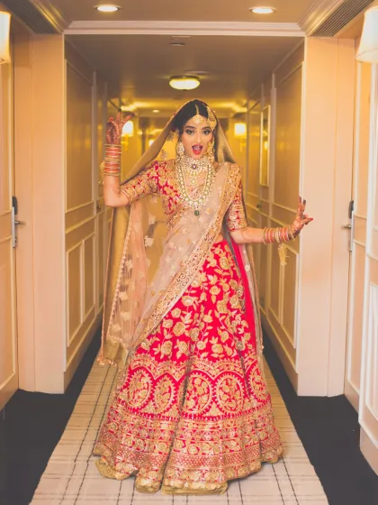 A fun and expressive portrait of a bride in a hotel corridor. Her playful pose shows her excitement and personality, adding a touch of fun to the bridal album.
