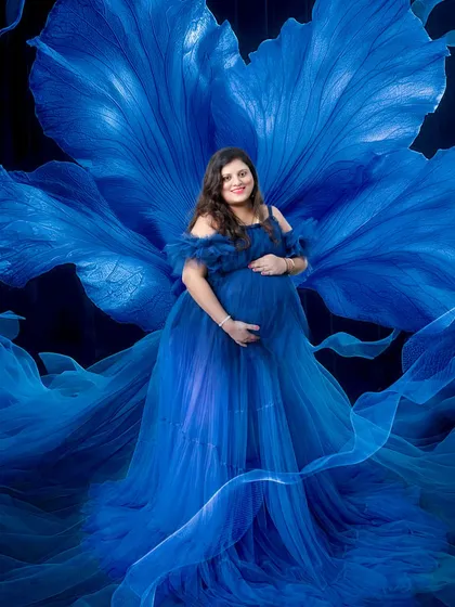 The blue gown is another popular choice from my collection. Combined with the flowing fabric and floral backdrop, it creates a dreamy, ethereal look for your maternity portraits.