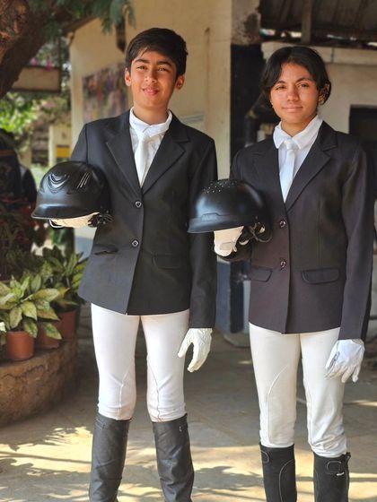 Two of our young riders in their formal competition attire. We instill a sense of professionalism and pride in our team from the very beginning.