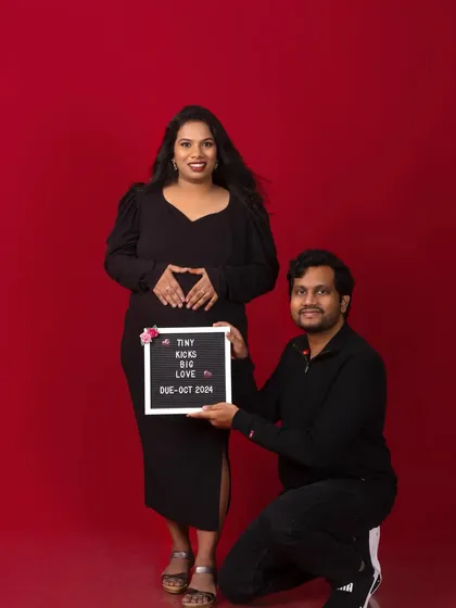 A sweet announcement photo with a chalkboard sign. The simple red background makes the couple and their message pop.