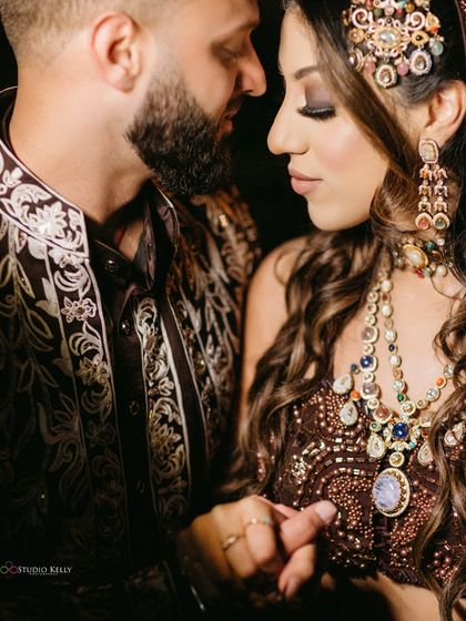 A detailed close-up focusing on the bride's stunning jewelry and the couple's gentle touch, showcasing the intricate beauty of their wedding attire.