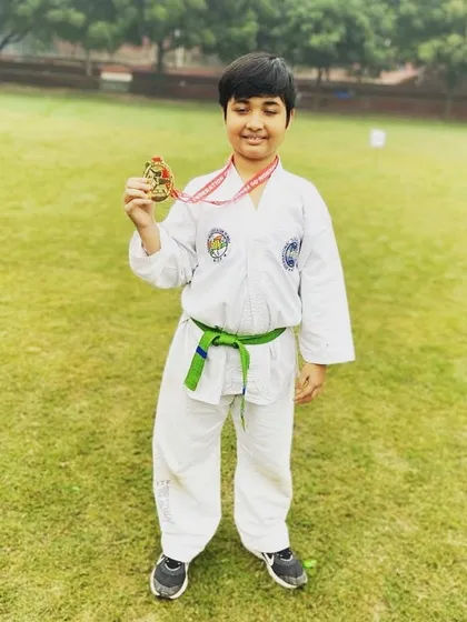 A young green-belt student proudly holding his Gold medal from the state competition. We nurture talent at every belt level, preparing them for success.