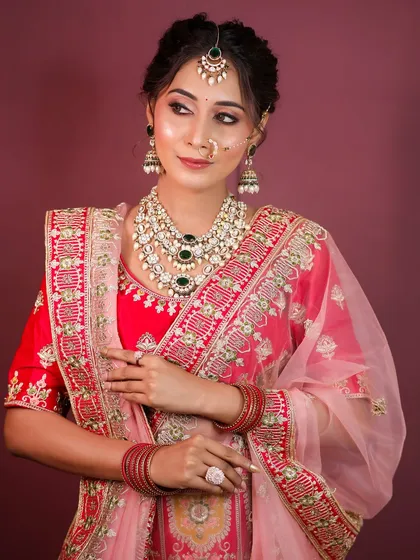 The full look, showing the vibrant red lehenga and how the makeup complements the outfit without overpowering it.