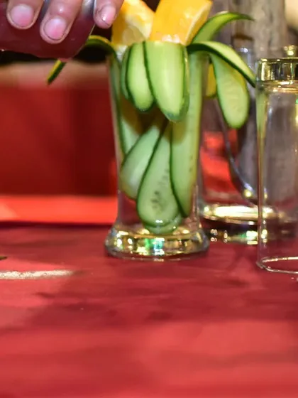 Preparing a refreshing drink with fresh cucumber ribbons and lemon slices. I believe in using fresh, high-quality garnishes to elevate every cocktail.