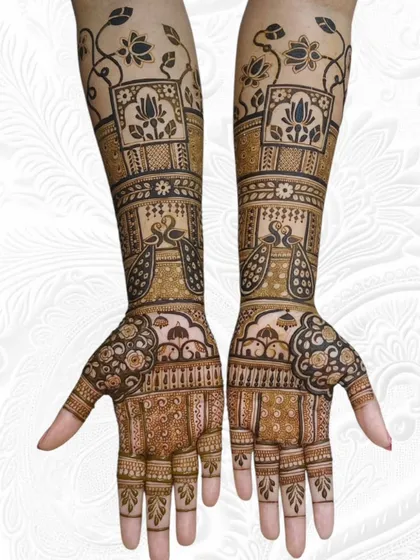 A beautiful engagement design featuring symmetrical peacocks and lotus motifs framed in panels, extending up the arms.