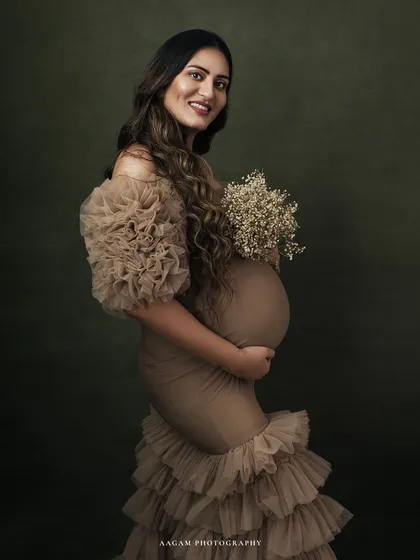 Holding a bouquet of baby's breath, she embodies the delicacy and strength of motherhood. The soft lighting enhances her gentle expression.