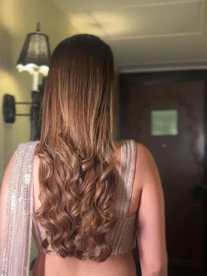 The back view of a sleek half-up style with soft waves. This is a great way to keep hair off the face while still showing off its length.