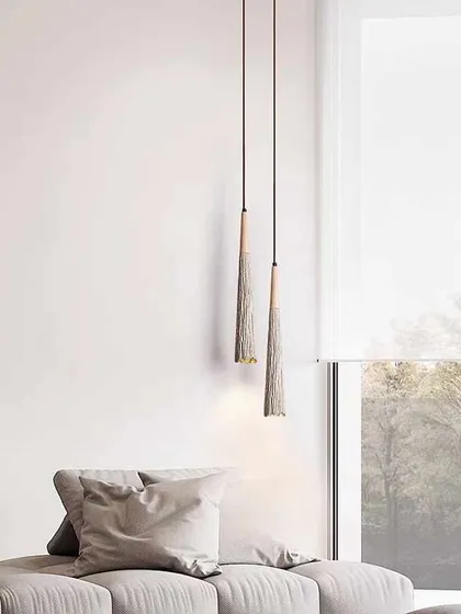 A pair of slender, textured pendants that add a rustic, modern touch to this living room.