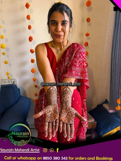 A happy client showcasing her full bridal henna. The intricate design covers both hands and arms, ready for her wedding festivities.