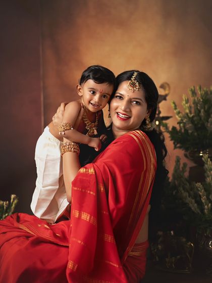 A mother holds her little Krishna, her face full of love and pride.