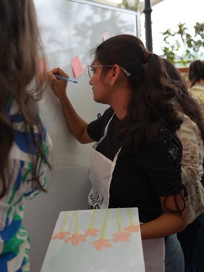 A participant writing on a whiteboard during the Meesho event, a great way to share feedback and positive messages.