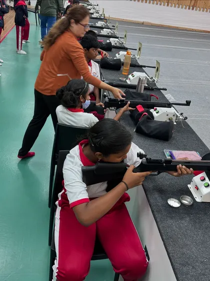 A coach provides hands-on instruction to a student from Carmel Academy. This one-on-one attention is crucial for correcting form and building confidence in new shooters.
