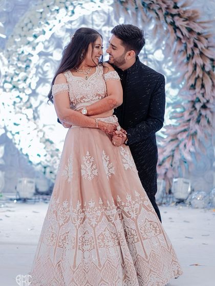 A beautiful portrait of the couple on their Sangeet stage, sharing a look of love and happiness.