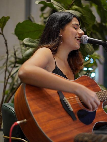 A happy moment, singing and playing at a cafe gig. The greenery in the background added to the cozy, organic feel.