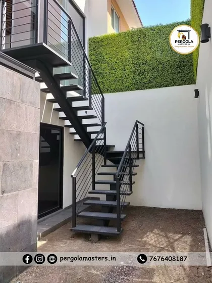 This L-shaped exterior staircase is designed to fit perfectly in a narrow courtyard space. The simple, clean lines of the metal frame and railings provide functional access without overwhelming the compact area.