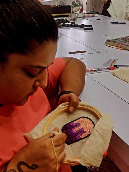 Another shot of a participant deeply focused on her punch needle piece. You can see the intricate details and textures starting to form.