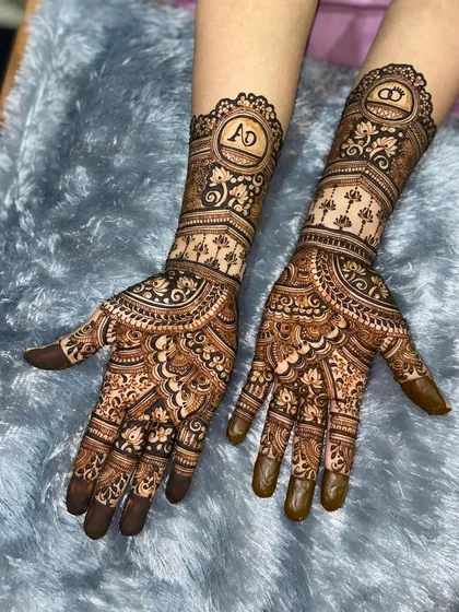 A beautiful engagement design personalized with the couple's initials, 'A' and 'D', enclosed in ornate circles at the center of each palm.