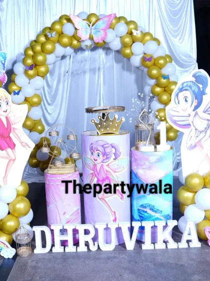 A magical fairy and butterfly theme with gold and white balloons. The large fairy cutouts and themed pedestals create a beautiful and cohesive look.
