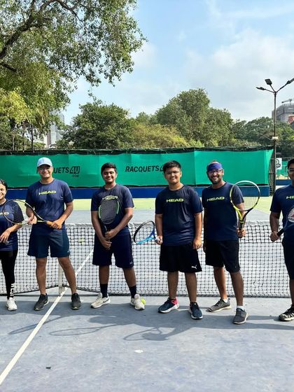 The TenniStation team posing on the court. We are a community of players who train together, grow together, and succeed together.