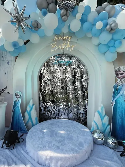 Let it go, let it go! I created a winter wonderland for a 'Frozen' themed party, complete with a sparkling sequin backdrop, character cutouts of Elsa and Olaf, and faux snow for a truly immersive Arendelle experience.