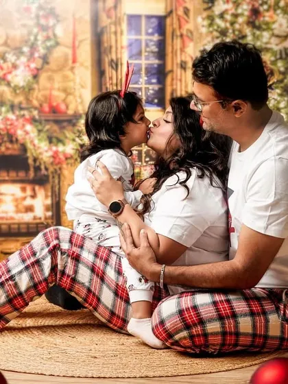 A sweet holiday kiss. We love capturing the love and affection between family members, especially during a cozy Christmas-themed family photoshoot.