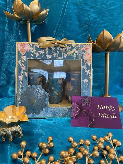 A stunning teal and gold floral box containing three decorated glass jars. This hamper is perfect for gifting sweets or dry fruits with a touch of festive elegance.