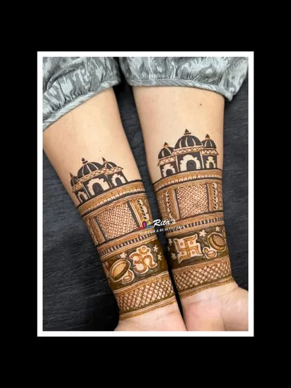 A close-up of the arm design, showing the temple architecture and auspicious symbols like Om and Swastik.
