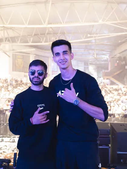 On stage with a fellow DJ, with the huge concert audience visible behind us. This highlights my experience as a collaborative performer on a large stage.