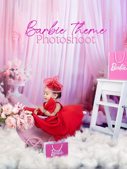 A Barbie-themed photoshoot in a stunning red dress. The pink backdrop and props create a beautiful, glamorous world for this little princess.