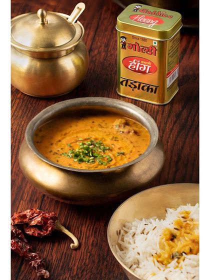 This image for Goldiee Masale captures the essence of a comforting Indian meal. The traditional brass bowls and rich colors of the dal and spices create a warm, inviting photo that speaks to home-cooked goodness.