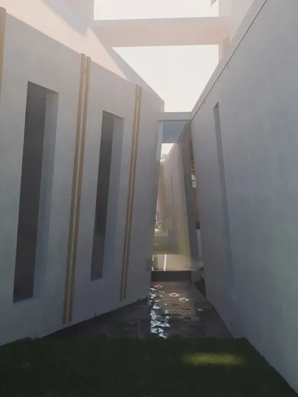 A narrow passage between two building masses in the Cumin Residence design, creating an interesting play of light, shadow, and perspective.