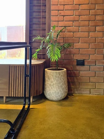A duplicate image showing the terrazzo planter against a brick wall, perfect for a modern yet rustic interior.