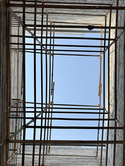 Looking up through a scaffold-filled light-well to the sky. This image captures a moment in the making, a frame for the sky that will soon be a source of light for the finished building.
