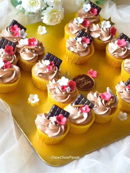 This set of choco-vanilla cupcakes was ordered for a birthday celebration. A small 'Happy Birthday' disc is included alongside the beautifully decorated cupcakes.