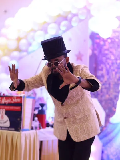 Striking a magical pose during a princess-themed birthday party. My classic magician's outfit, complete with a top hat and a stylish jacket, adds to the theatrical experience.