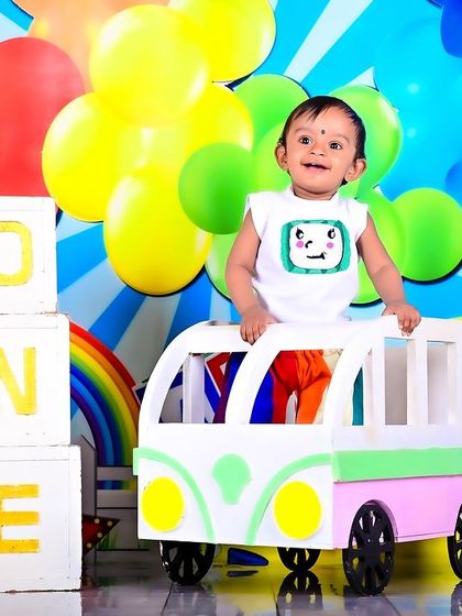 A vibrant Cocomelon-themed shoot with a baby in a colorful bus prop.