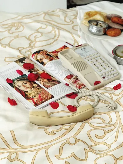 A flat-lay style image setting the scene for a "weekend getaway" hotel shoot. The composition includes a vintage phone, magazines, and breakfast, creating a narrative of relaxation.