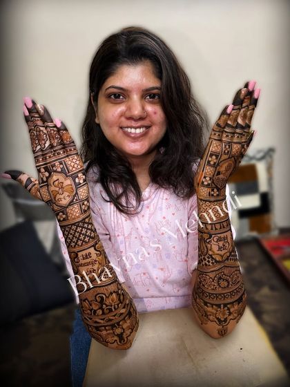 A happy client showing her full bridal mehndi. The design is a beautiful mix of traditional patterns and personal touches, created to make her feel special on her wedding day.