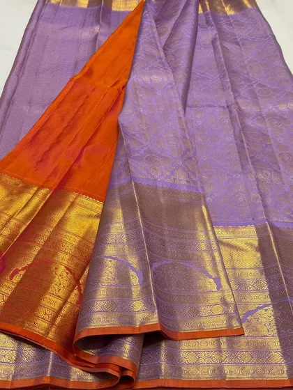 The full drape of the lavender Kanchi Pattu saree, showing the contrasting orange pallu.