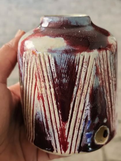 A small vase, fresh out of the kiln. The carved lines and the way the glaze has broken over them create a beautiful, textured effect.